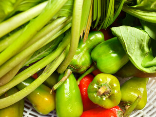 mustard greens and several large chilies in the basket