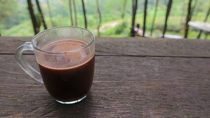 Glass mug of hot chocolate drink isolated on wooden table with clipping path.