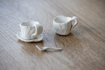 Close-up on two small coffee cups made of clay. Homemade clay objects.