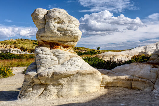 The Paint Mines of Calhan, Colorado.  Interpretative natural site of stone monoliths.  Stone structures with sandy soil and blue sky with puffy clouds.