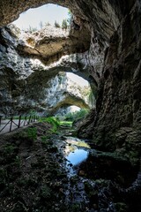 Stunning view of Devetashka Cave in Bulgaria, featuring rocky walls and natural holes.