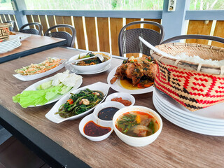background of a diverse food menu from spiced fried chicken, stir-fried water spinach, fish curry, vegetable bakwan and fresh vegetables at the Kampong Laok restaurant