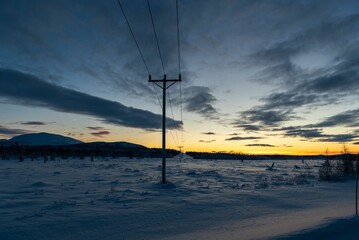 Majestic winter scene of a snow-covered landscape illuminated by a spectacular sunset sky.