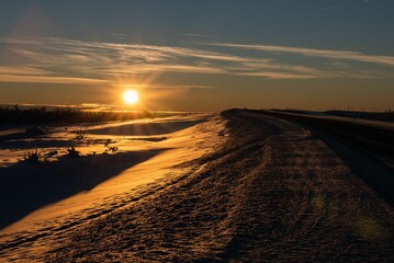 Majestic winter scene of a snow-covered landscape illuminated by a spectacular sunset sky.