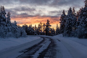 Majestic winter scene of a snow-covered landscape illuminated by a spectacular sunset sky.