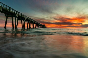 Wooden pier extending into the horizon at dusk in Panama Beach, Florida