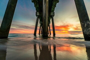 Wooden pier extending into the horizon at dusk in Panama Beach, Florida
