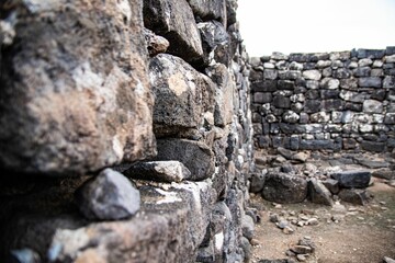 the view from behind a stone wall to the sky and ground