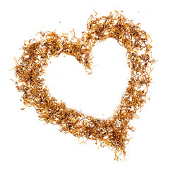 A pile of shredded tobacco for cigarette rolling in a heart shape, top view, isolated on a...