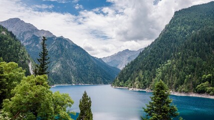 Scenic view of a forest with a lake in Jiuzhaigou, Sichuan Province, China. - obrazy, fototapety, plakaty
