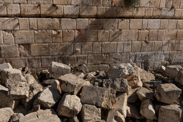 Large rock pile at the base of the Western Wall in Jerusalem, beneath Robinson's Arch, believed to be ruins of the Second Jewish Temple destroyed by the Romans in 70 AD. - obrazy, fototapety, plakaty
