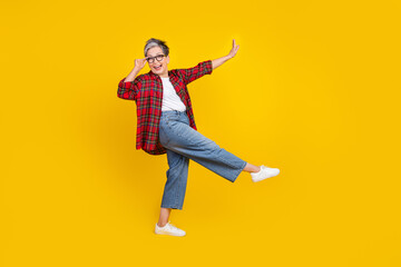 Full size profile portrait of carefree cheerful grandmother dancing clubbing empty space isolated on yellow color background