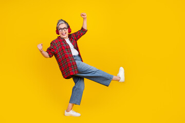 Full body profile portrait of cheerful person raise fists dancing listen new playlist empty space isolated on yellow color background - obrazy, fototapety, plakaty