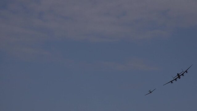 Vintage military airplanes spitfire hawker hurricane in Battle of Britain reenactment flying low in display.
