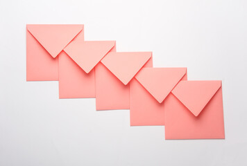 Pink square paper envelopes on white background