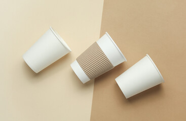 Disposable cardboard cups for hot drinks on a beige background