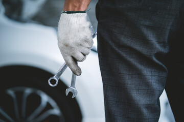 A mechanic is holding a pair of wrenches in his hand. Concept of professionalism and expertise, as the mechanic is likely working on a car or other mechanical device