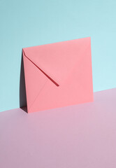 Pink square paper envelope on pastel background