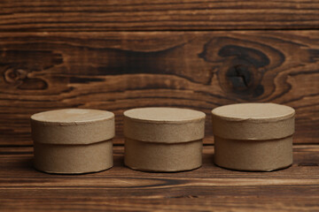 Round craft cardboard boxes for product on wooden background