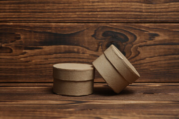 Round craft cardboard boxes for product on wooden background