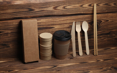 Disposable eco consumables for cafe and delivery on wooden background