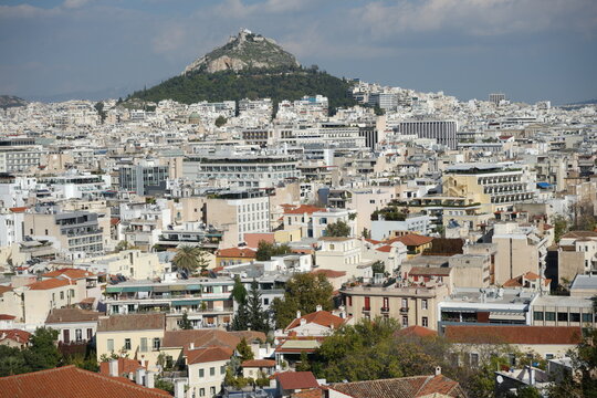 View of the city of Athens with Lykavitos mountain in the background and few of the houses of the Plaka neighborhood in the foreground