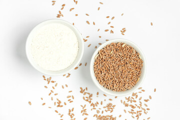 Fototapeta na wymiar Bowl with wheat grains and flour on white background