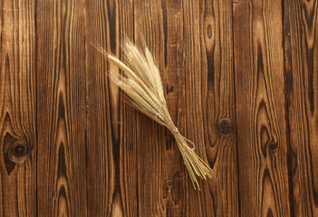Dry rye spikelets on a wooden table. Top view