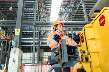 Female engineer working in electric train repair shop, Inspecting small grinding the railroad tracks machine before being put out for use.