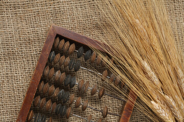 Abacus with wheat spikelets on burlap background