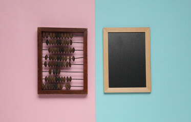 Abacus and chalkboard on a blue-pink background. Education concept