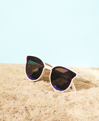 Fototapeta na wymiar Stylish sunglasses on the sand. Beach vacation