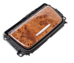 An opened ashtray from panel of car interior separately on a white isolated background with wooden decorative overlay.