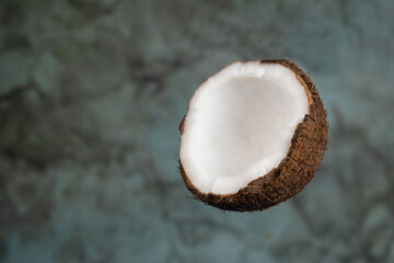 Half of a ripe coconut on a gray spotted background, copy space for text