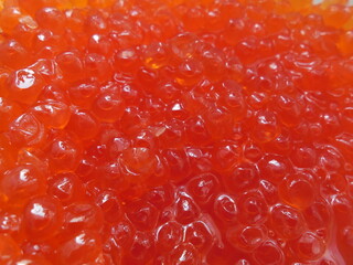 Juicy appetizing fresh red caviar, a thick layer of solid background.