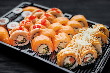 Sushi set with salmon on a black background, top view