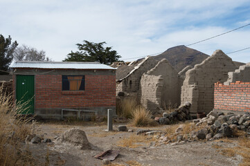Ruined mud houses in a village called Jirira in Bolivia and masonry houses replacing these houses