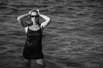 A young beautiful girl posing against the background of the sea