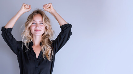 Naklejka premium Blonde businesswoman wearing black shirt, smiling and raised hands