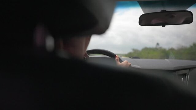 Slow motion view from back passenger seat of woman smoking electronic cigarette while driving a car. Most common traffic violation 