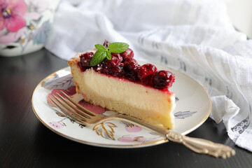 Appetizing portioned piece of cottage cheese tart and cherries on a porcelain plate. Tea party,...