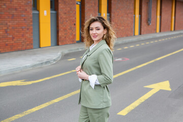 Obraz premium Portrait of a successful business woman in front of modern business building.Young manager poses outside. Female business leader. 