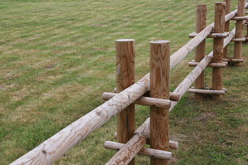 wooden fence on a green meadow.