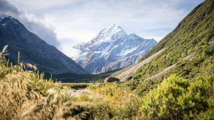 Naklejka na ściany i meble Massive snowy mountain with glacier towering above scenic alpine valley, Mt Cook, New Zealand