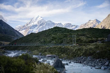 Crédence de cuisine en verre imprimé Aoraki/Mount Cook Tourists crossing swing bridge above glacial river in alpine environment, Mt Cook, New Zealand