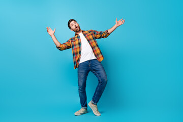 Full length photo of nice young guy dance excited discotheque dressed stylish checkered garment isolated on blue color background