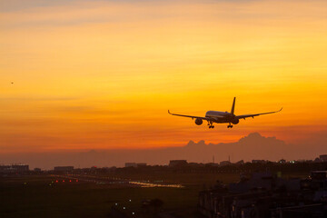 An Commercial Airplane Landing At Sunset.