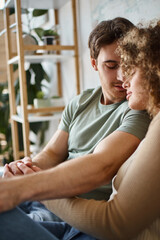 curly young woman and brunette man hugging lovingly, feeling grateful for the moment