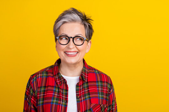 Photo of positive minded lady beaming smile look interested empty space isolated on yellow color background