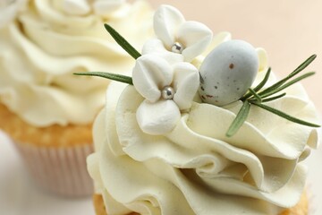 Tasty Easter cupcakes with vanilla cream on table, closeup